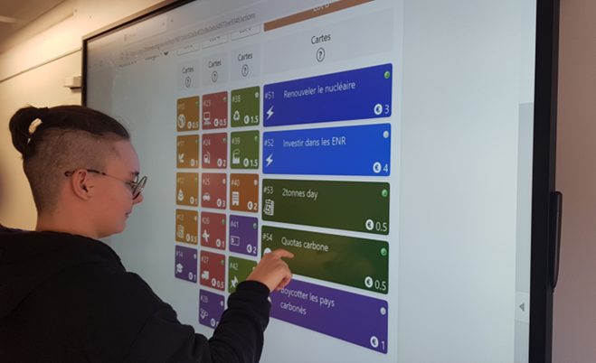 Étudiante au TBI sélectionnant des options pour réduire sont impact carbone lors de l'atelier2tonnes